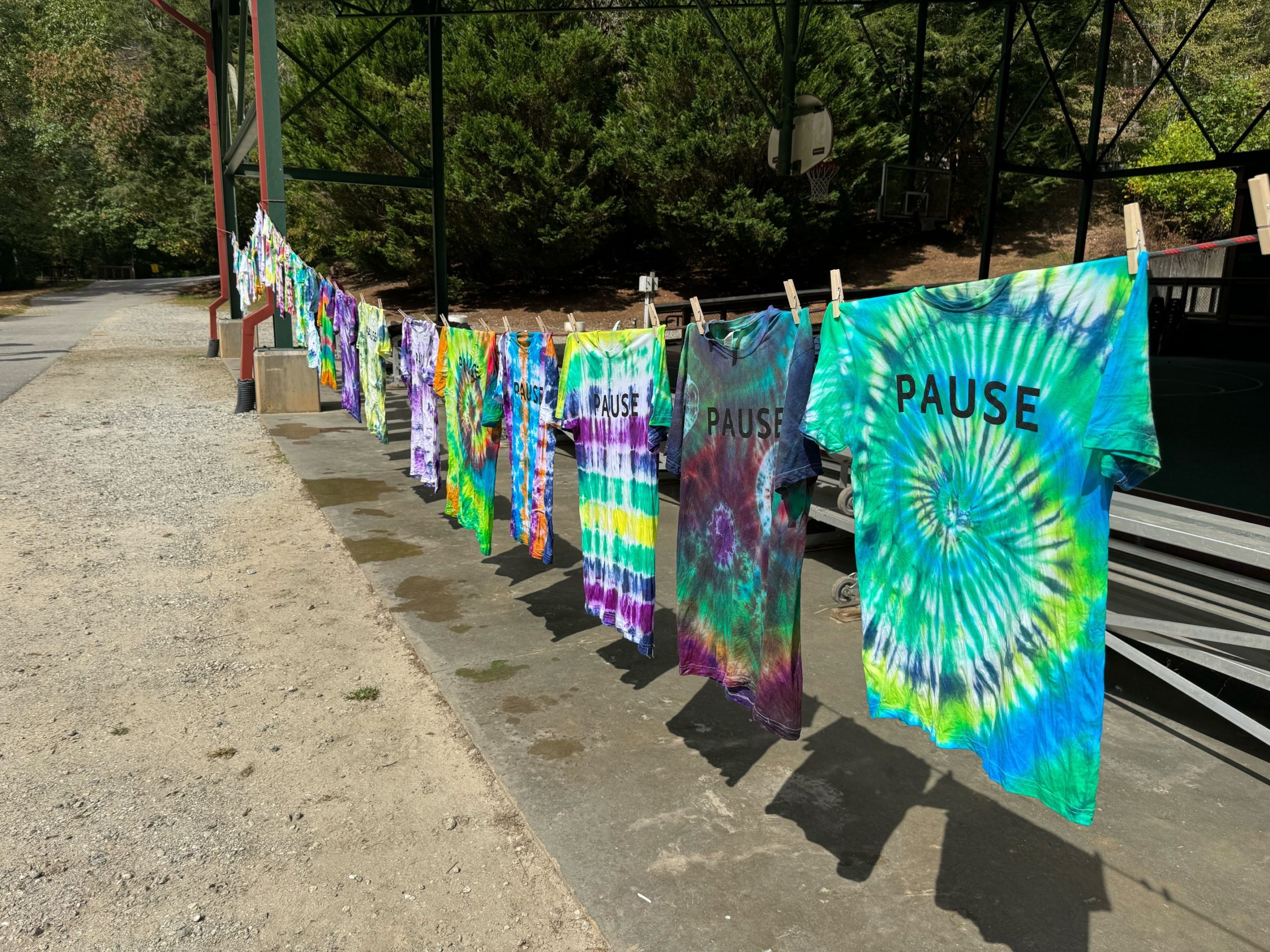 Tie-dye PAUSE shirts hanging at PauseOnError